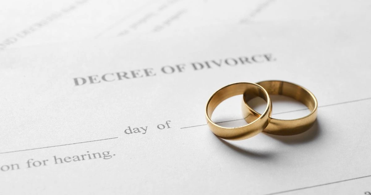 Divorce papers with two gold wedding bands on it